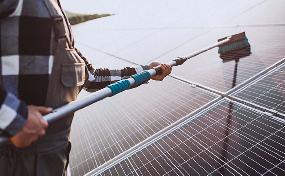 Man worker in the firld by the solar panels