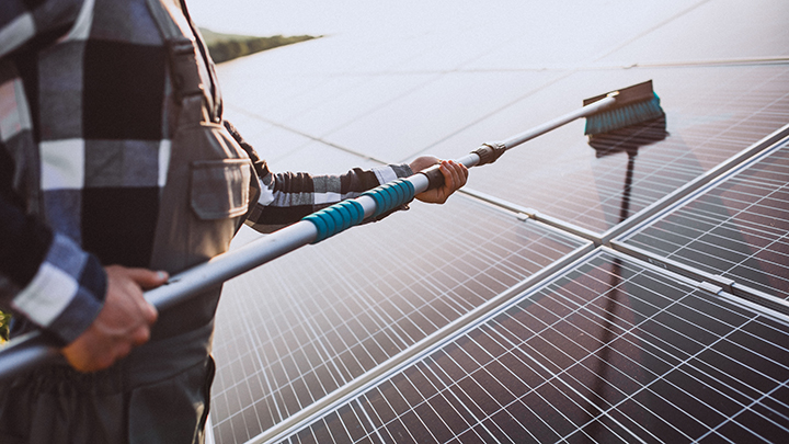 Man worker in the firld by the solar panels