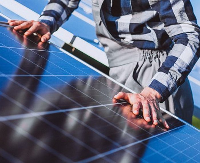 Man worker in the firld by the solar panels