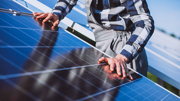 Man worker in the firld by the solar panels